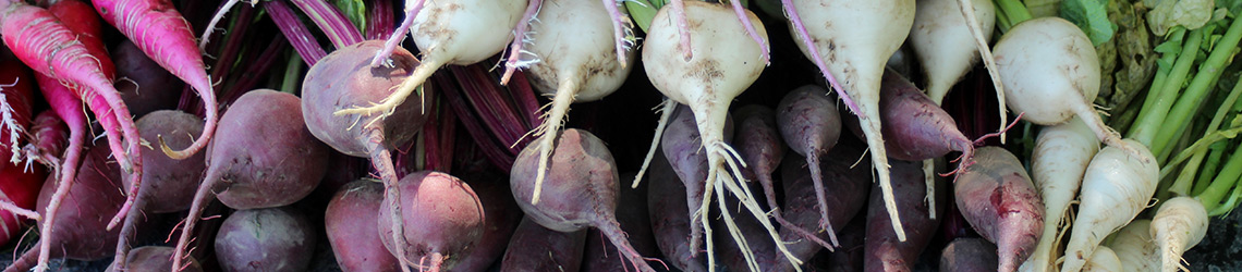 A pile of beets, ranging from purple to white