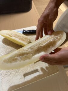 A large yellow cucumber cut in half lengthwise