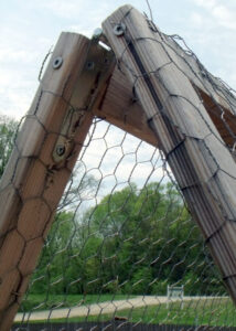 Two wooden frames wrapped in chicken wire coming together at an A-frame angle