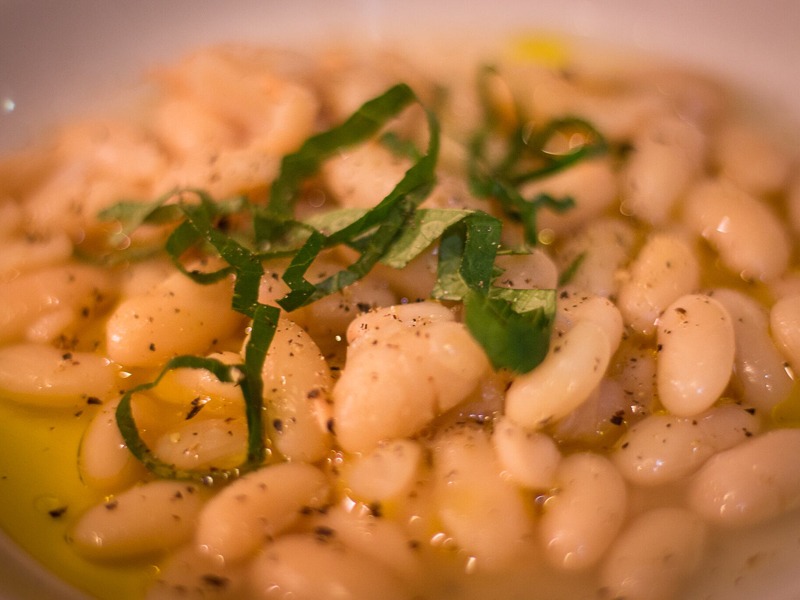 A dish of white beans with a green garnish