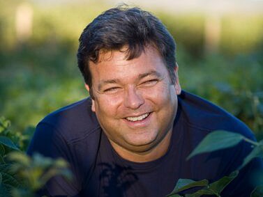 A man smiles outdoors