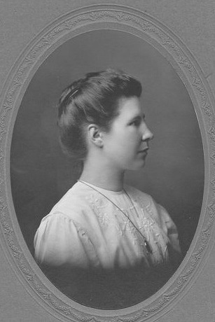 An old, black and white portrait of a woman looking to her left, framed in an oval