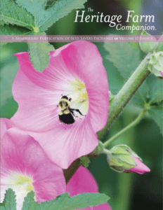 The cover of a "Heritage Farm Companion" magazine with a photo of a bumblebee inside a large pink flower.