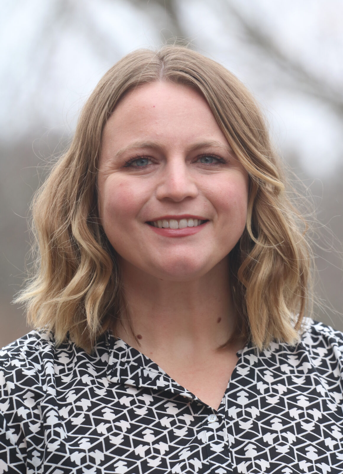 A woman with blond hair smiles into the camera