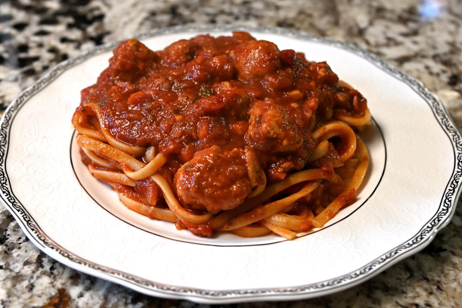 Nanas pasta sauce with meatballs and spaghetti on a plate.