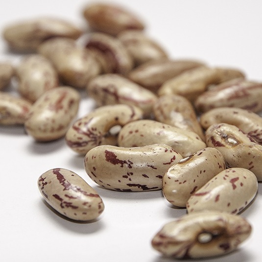 A cluster of peach colored beans with red speckles