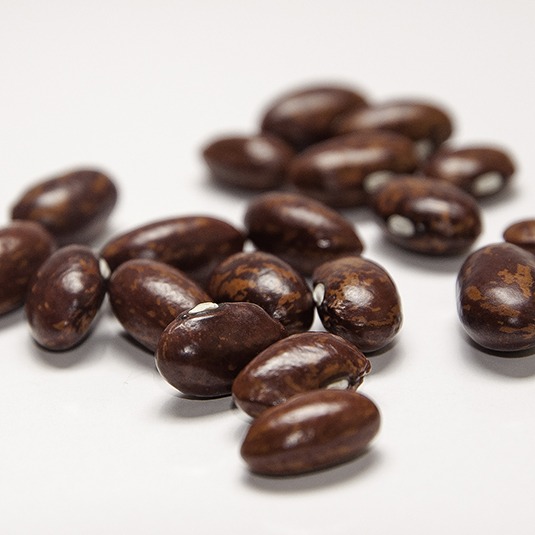 A group of bright red mottled beans