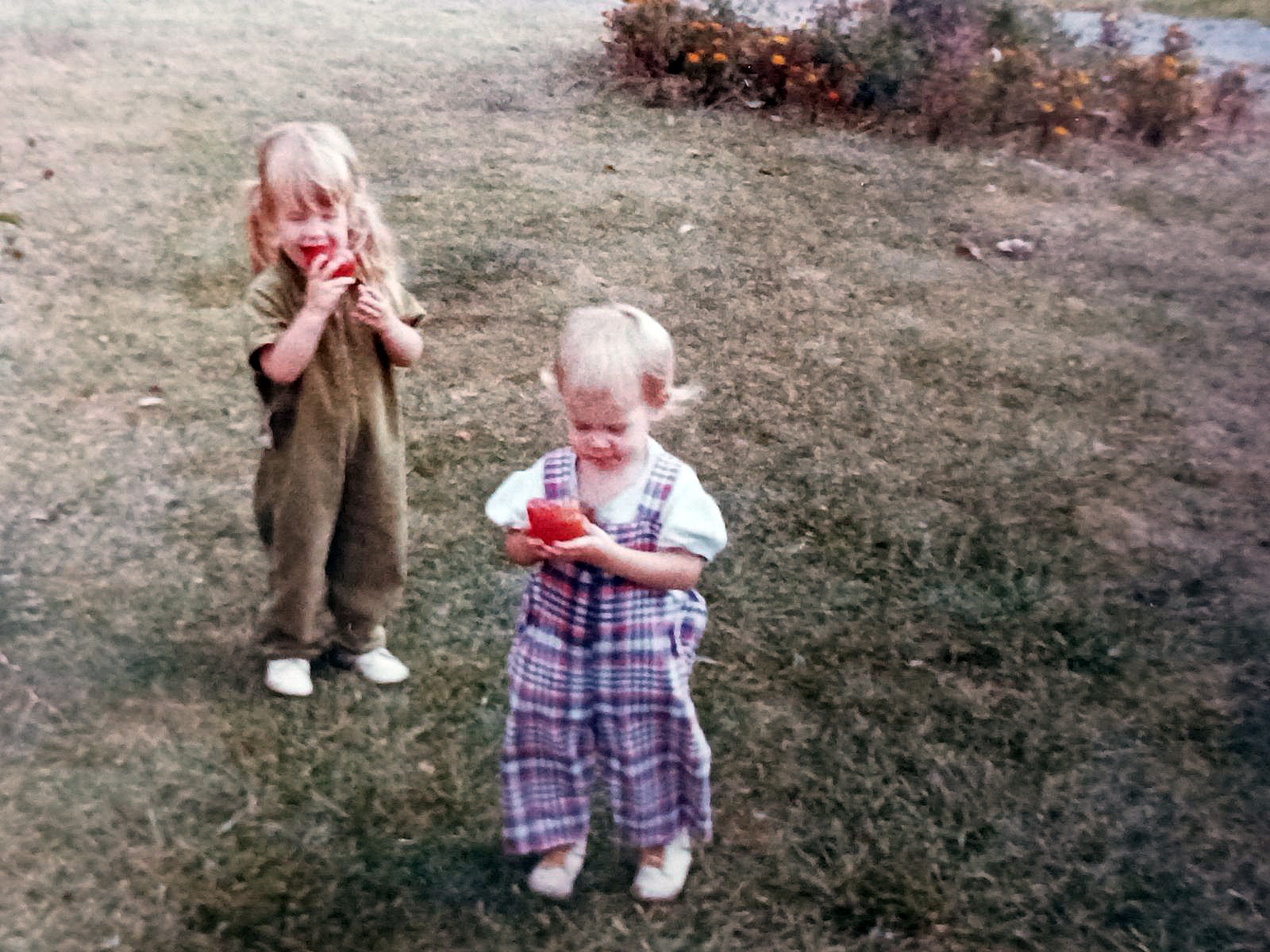 stevens_niki_smith_katrina two little girls in bib overalls holding tomatoes