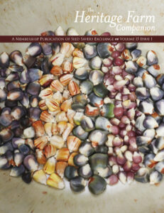 Cover of The Heritage Farm Companion, Volume 15, Issue 1, a membership publication of Seed Savers Exchange. The background features a close-up photograph of multicolored corn kernels—shades of deep purple, blue-gray, dusty rose, golden yellow, cream, and green—scattered in a rustic, cream-colored bowl. A maroon banner across the top reads, “A Membership Publication of Seed Savers Exchange • Volume 15 Issue 1,” with the publication title set in elegant white serif lettering above the image.
